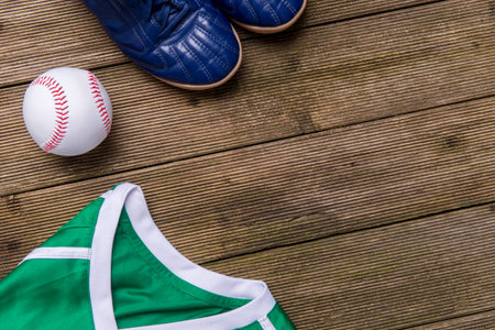 Baseball ball, shirts and shoes on old wooden background. Team sport