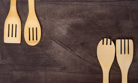 Top view of various wooden cooking utensils on grey background. Zero waste concept
