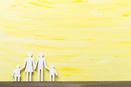 Happy family on yellow wooden backgroundの写真素材