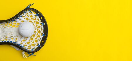 Lacrosse ball and stick on yellow background. Team sport conceptの写真素材
