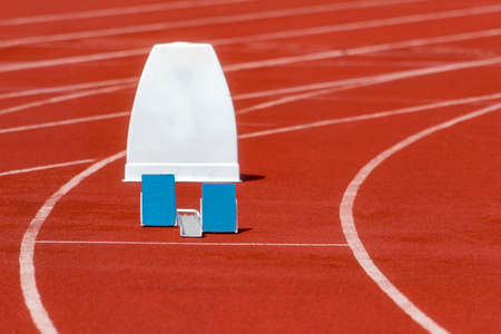 Athletic start block on dark red tartan track. Individual sport conceptの写真素材