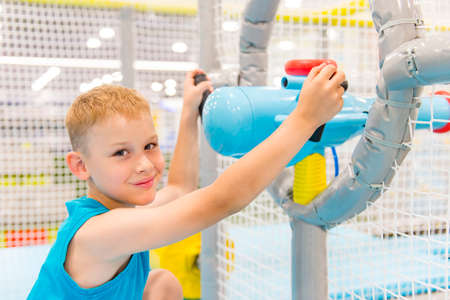 Smiling kids plays with air gun in children game center.の写真素材