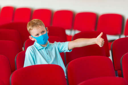 School kid with blue mask against virus at lesson. Safe back to school during pandemic concept. Social distancing to fight COVID-19の写真素材