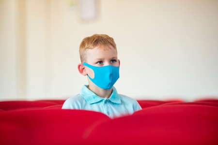 School kid with blue mask against virus at lesson. Safe back to school during pandemic concept. Social distancing to fight COVID-19の写真素材