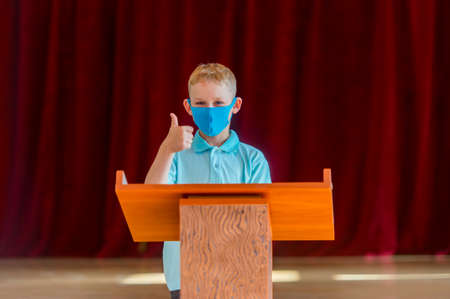 School kid with blue mask and  ball in a physical education lesson. Safe back to school during pandemic concept. Social distancing to fight COVID-19の写真素材