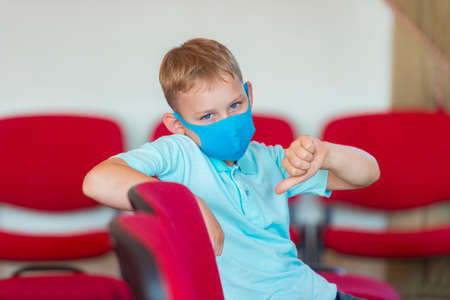 School kid with blue mask and  ball in a physical education lesson. Safe back to school during pandemic concept. Social distancing to fight COVID-19の写真素材