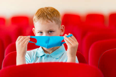 School kid with blue mask and  ball in a physical education lesson. Safe back to school during pandemic concept. Social distancing to fight COVID-19の写真素材