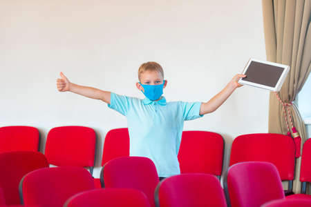 School kid with blue mask and  ball in a physical education lesson. Safe back to school during pandemic concept. Social distancing to fight COVID-19の写真素材