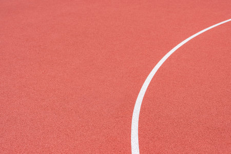 Close up on a white line in artificial red turf, on a street basketball, handball, volleyball, futsal, rugby, hockey and football field, in a sports backgroundの写真素材