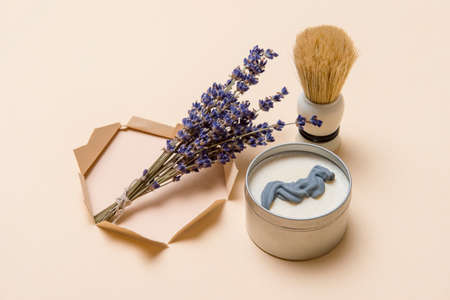 Shaving brush, dried lavender and shaving foam on camel color background. Spa organic foam. Zero waste conceptの写真素材