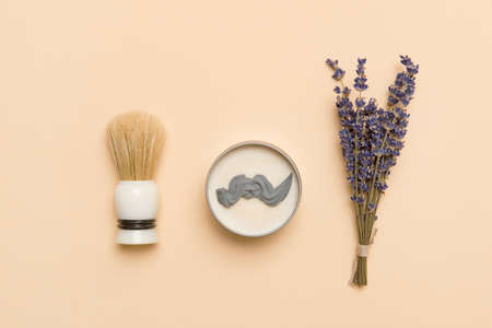 Shaving brush, dried lavender and shaving foam on camel color background. Spa organic foam. Zero waste conceptの写真素材