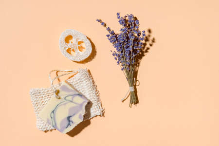 Natural handmade soap, loofah sponges with dried lavender and essential oil on cream color background. Zero waste conceptの写真素材