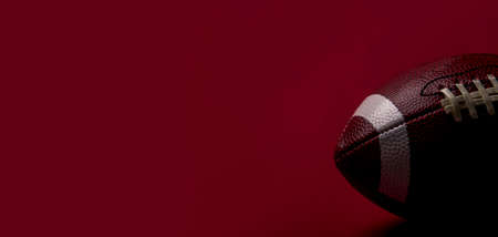 American Football ball close up on red background. Spot team conceptの写真素材