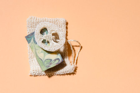 Handmade hemp soap and loofah sponges on a beige background. Eco lifestyle concept.の写真素材