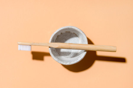 Bamboo toothbrush in holder on beige background. Zero waste conceptの写真素材