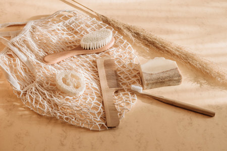 Zero waste bathroom accessories hairbrush, bamboo toothbrush, loofah and natural soap in reusable shopping bag on beige background. Top view. Vintage color filterの写真素材