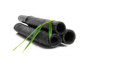 Bamboo activated charcoal sticks and green leaf isolated on white background.の写真素材