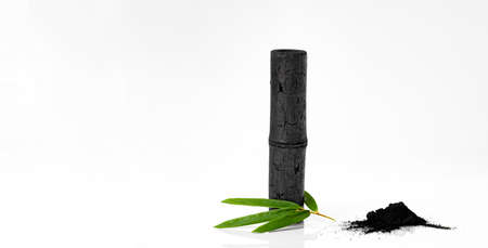 Bamboo activated charcoal stick, green leaf and coal powder isolated on white backgroundの写真素材