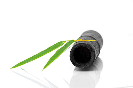 Bamboo activated charcoal sticks and green leaf isolated on white backgroundの写真素材