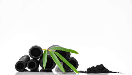 Bamboo activated charcoal sticks green leaf and coal powder isolated on white backgroundの写真素材