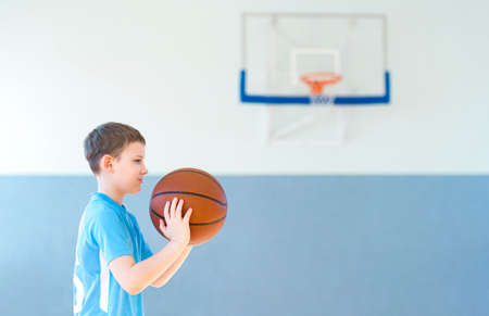 School kid playing basketball in a physical education lesson. Safe back to school during pandemic conceptの写真素材
