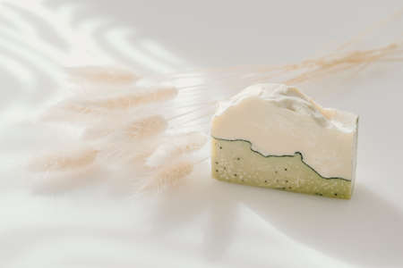 Handmade soap and dried bunny tail grass. Sunshade shadow on white background. Zero waste, eco friendly cosmetics concept. Vintage color filterの写真素材