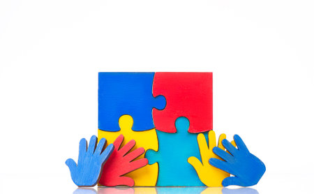 Colorfull puzzles hands on white background. World Autism Awareness Day Concept