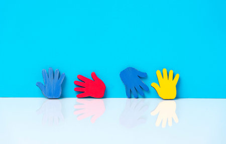 Colorfull puzzles hands on blue background. World Autism Awareness Day Concept