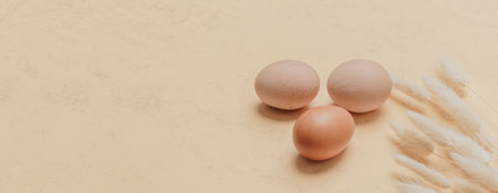 Brown dried bunny tail grass and eggs on natural beige background. Zero waste easter concept. Eco friendly lifestyle, copy spaceの写真素材