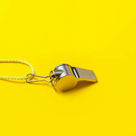 Sports whistle on yellow background. Concept- sport competition, referee, statistics, challenge. Basketball, handball, futsal, volleyball, soccer, baseball, football and hockey referee whistleの写真素材