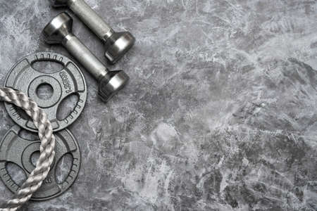 Close up of battle rope  and dumbbells on a gray backgound. Sport and fitness equipment. Functional trainingの写真素材