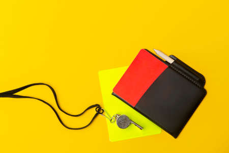 Football soccer referee equipment on yellow background. Top view, space for your text. Sport conceptの写真素材
