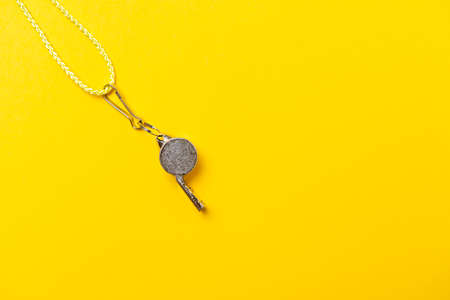 Sports whistle on yellow background. Concept - sport competition, referee, statistics, challenge. Basketball, handball, futsal, volleyball, soccer, baseball, football and hockey referee whistleの写真素材