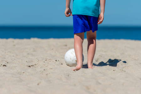 Young boy playing soccer on beach. Summer sport conceptの写真素材