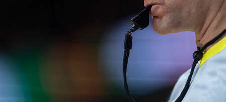 Referee with whistle on colorful background. Professional sport conceptの写真素材