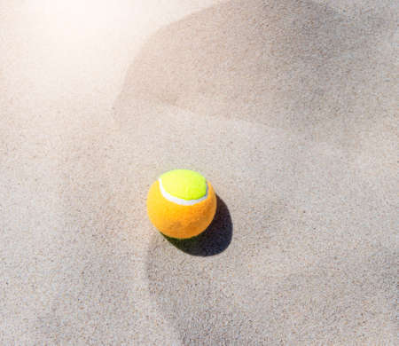 Tennis ball on the sand at the beach close up. Professional sport conceptの写真素材
