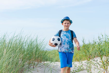 Young boy play soccer ball on the beach. Summer sport concept. Horizontal sport poster, greeting...