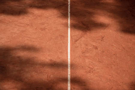 Orange tennis court white lines with shadows. Sport, recreation and training concept. Background for tennis, rugby, cricket, baseball and paddle bannerの写真素材