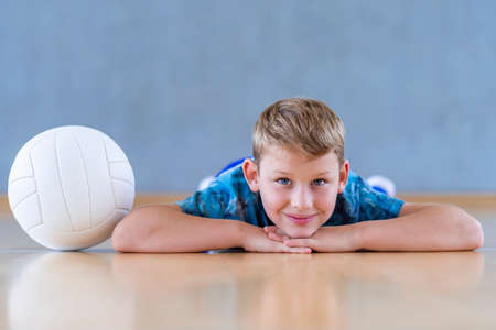 School kid playing volleyball in a physical education lesson. Horizontal education poster, greeting cards, headers, website.Safe back to school during pandemic conceptの写真素材