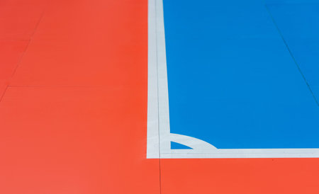 The futsal field in close up scene at the corner of the field. Blue and orange floor futsal, handball court. Wooden floor of sports hall with marking lines line on wooden floor indoor, gym courtの写真素材