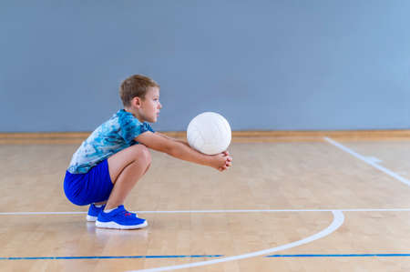 School kid playing volleyball in a physical education lesson. Horizontal education poster, greeting cards, headers, website.Safe back to school during pandemic conceptの写真素材
