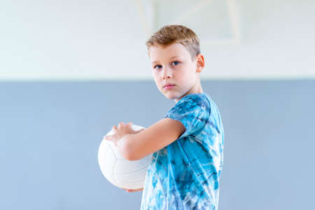 School kid playing volleyball in a physical education lesson. Horizontal education poster, greeting cards, headers, website.Safe back to school during pandemic conceptの写真素材
