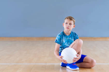 School kid playing volleyball in a physical education lesson. Horizontal education poster, greeting cards, headers, website.Safe back to school during pandemic conceptの写真素材