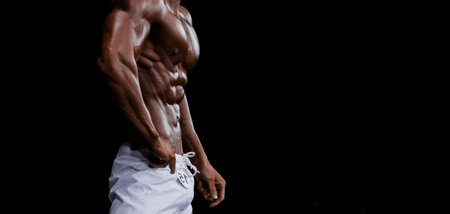 Athlete bodybuilder in white summer shorts at competitions in beach bodybuilding. Black and white filter. Horizontal sport poster, greeting cards, headers, website.の写真素材