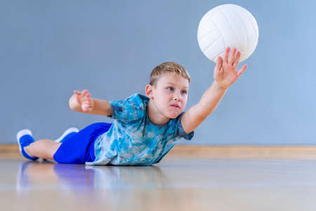 School kid playing volleyball in a physical education lesson. Horizontal education poster, greeting cards, headers, website.Safe back to school during pandemic conceptの写真素材