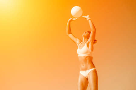 Young girl playing volleyball on the beach. Yellow color filter. Professional sport concept. Horizontal sport poster, greeting cards, headers, website and appの写真素材