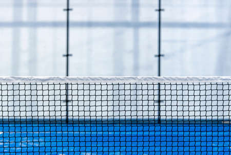 Paddle tennis and tennis net on blue court. Tennis competion concept. Horizontal sport poster, greeting cards, headers, websiteの写真素材