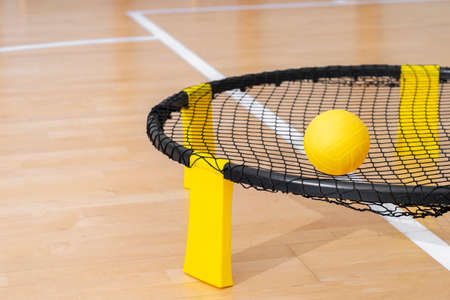 Spike ball game with yellow ball on hardwood court floor. Horizontal sport theme poster, greeting cards, headers, website and appの写真素材