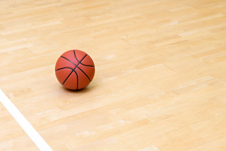 Basketball on hardwood court floor with natural lighting. Workout online concept. Horizontal sport theme poster, greeting cards, headers, website and app