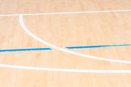 Wooden floor  basketball, badminton, futsal, handball, volleyball, football, soccer court. Wooden floor of sports hall with marking blue and white lines on wooden floor indoor, gym courtの写真素材
